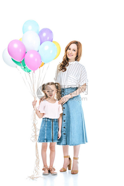 美丽的母亲和可爱的小女儿带着色彩多的气球微图片