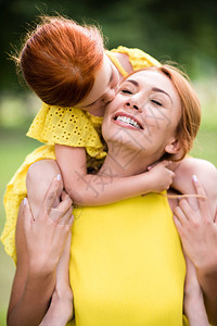 穿着黄色礼服的红发母亲和女儿在公图片
