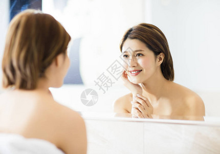 年轻女士在浴室照镜子图片
