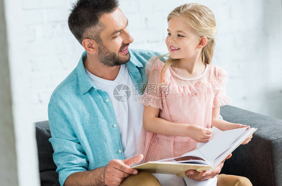 快乐的父亲和女儿在家中一起读书时图片