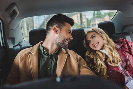 美丽的年轻快乐的情侣在坐车里坐在一背景图片