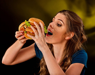 女人吃汉堡学生在桌子上吃快餐库克教授烹饪和分享食谱女孩急切地独自吃垃圾背景图片