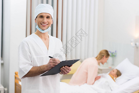 微笑着的医生在医院里写一些剪贴图片