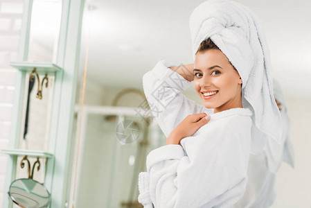 穿着浴袍和头戴毛巾的年轻美女在浴室里图片