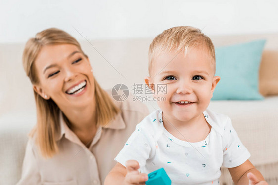 可爱的小孩男笑着和妈在室内玩耍图片