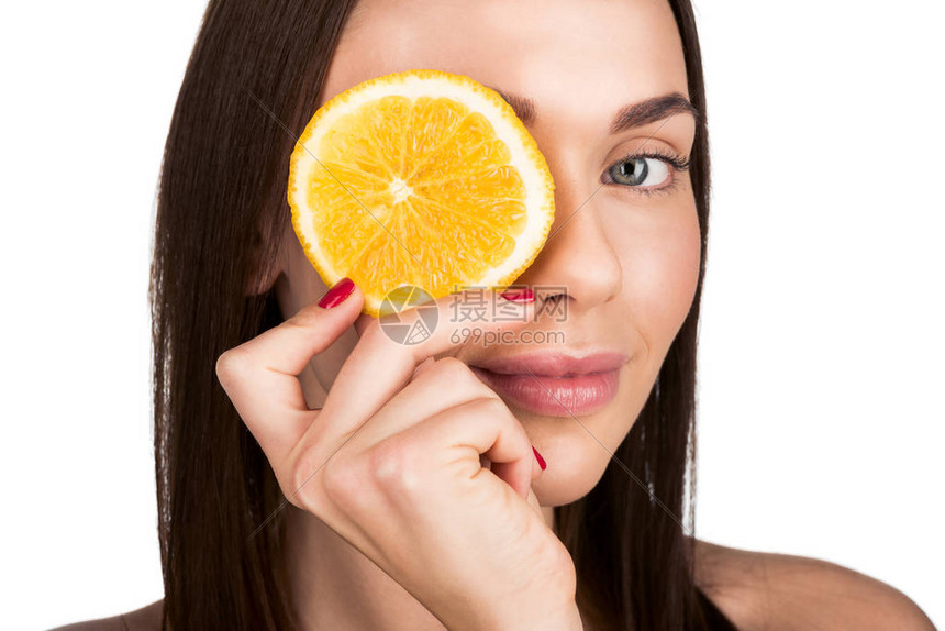 漂亮的女人用橙子片遮着眼睛以遮图片