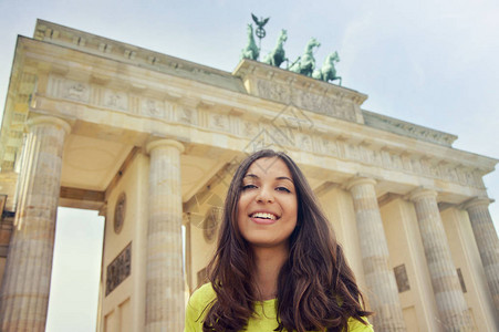 在德国柏林勃兰登堡门前微笑的快乐女孩美丽的年轻女子在欧洲旅图片