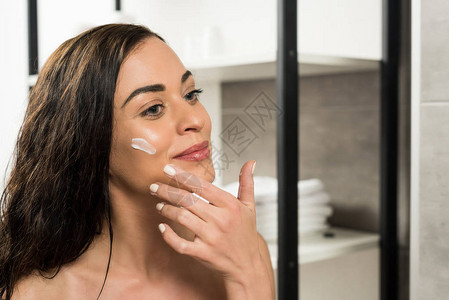 在浴室里照镜子时脸霜在脸颊上贴着面图片