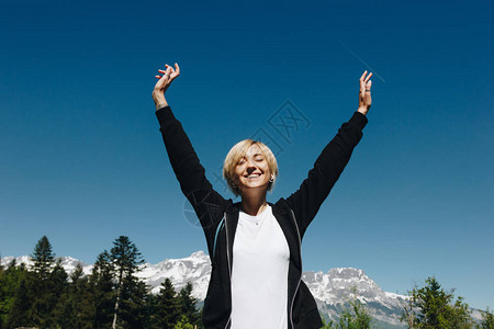 美丽的年轻快乐的女士在风景高山蒙白兰阿普斯站图片