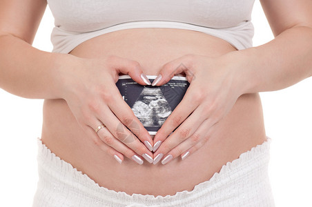 孕妇抱着她的胃和一张超声波照片并图片