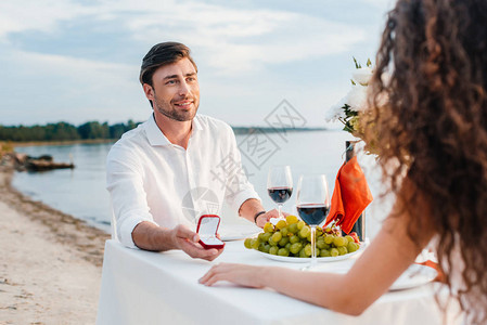 在户外浪漫约会时带着戒指向女朋友求婚的图片