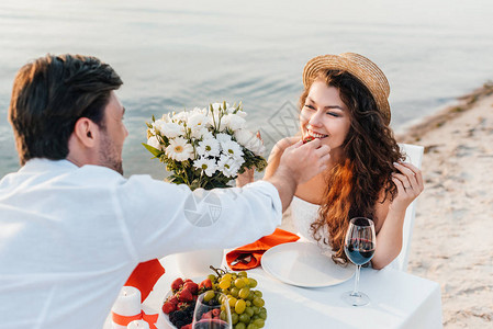 在海边浪漫约会期间男人用草莓给笑图片