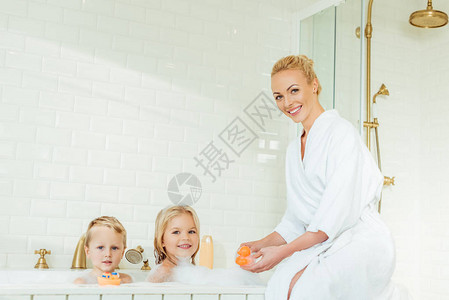 快乐的母亲和可爱的孩子在浴室图片