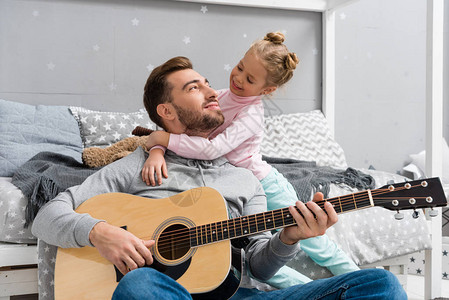 快乐的父亲弹吉他为女儿的女儿在儿童图片