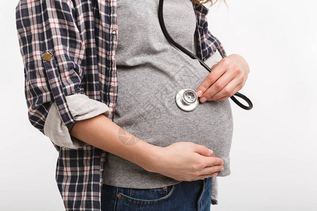 孕妇用在白色上隔离的听诊器监背景图片