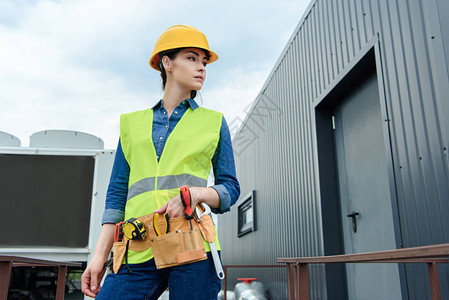 女工程师安全背心上带工具带和在建图片