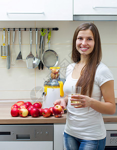 快乐的年轻姑娘在厨房里用果汁机图片