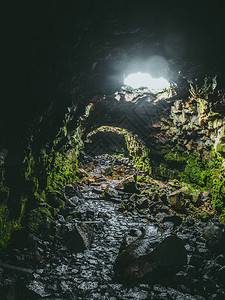 进入冰岛雷克雅未克附近的豪华熔岩隧道劳法霍尔谢利尔在拜萨勒特结构墙壁和从破碎的天花板上掉下来的光线上图片