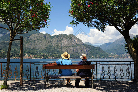 坐在一个果园前的长椅上坐着一对高级旅游夫妇图片