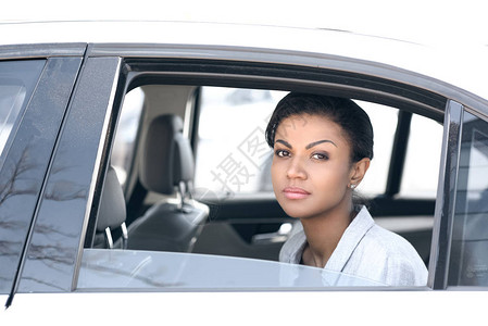 坐在车里看摄影机的美丽的年轻非洲女背景图片