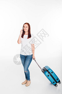 带着智能手机行李的微笑着微笑的女旅行者图片