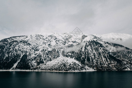 冰冷的阿尔卑斯山湖和雪覆盖的山峰图片