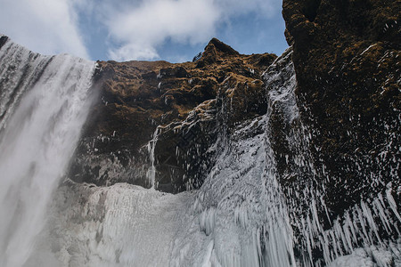 雄伟的斯科加瀑布冰岛岩石上结冰的柱图片