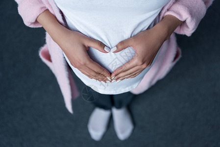 怀孕女孩用手在肚子上做心脏符图片