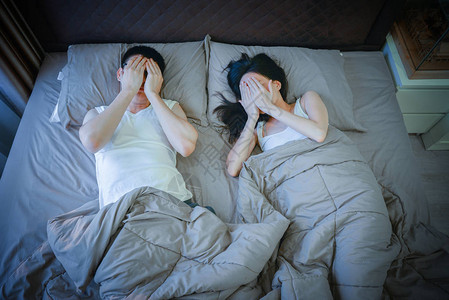 害羞的亚洲夫妇晚上睡在床上图片