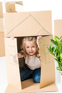可爱的小女孩坐在纸板箱内坐着房子用图片