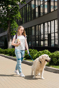 带着书的少女学生遛狗图片