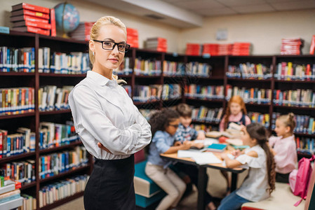 图书馆背景上孩子模糊不清的年轻老师图片