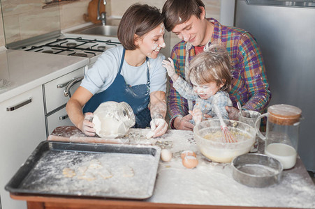 年青家庭在烘烤时在杂乱的厨房吃面图片