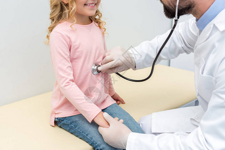 儿童医生听着小女孩呼吸的青春小背景