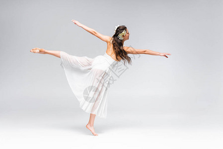 美丽优雅的芭蕾舞者穿着白色礼服在灰背景图片