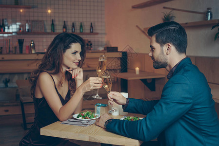 一对在餐厅浪漫晚宴时杯香槟相图片