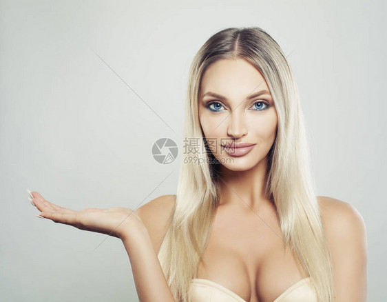 健康皮肤和头发在白背景开放的手上显示空间的微笑妇女滑脸模型面部治疗产品布局和广告营销概念图片