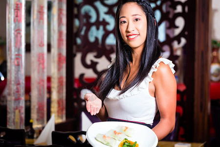 舒芙蕾拼盘在亚洲餐厅吃寿司的女服务员背景