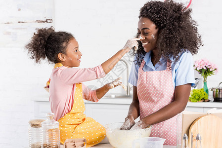 非裔美国母亲和女儿在厨房做饭时玩得开心图片