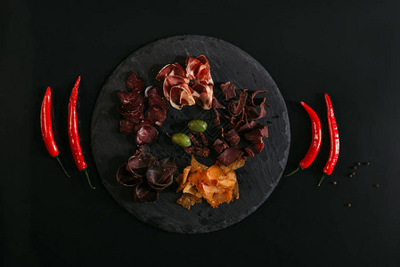 黑白板上含橄榄和辣椒的美食类肉背景图片