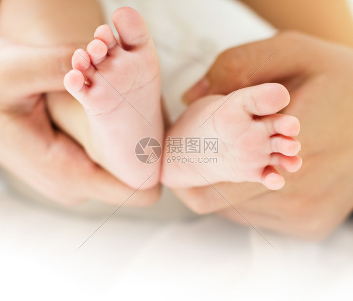 母亲手抱着刚出生的婴儿脚图片