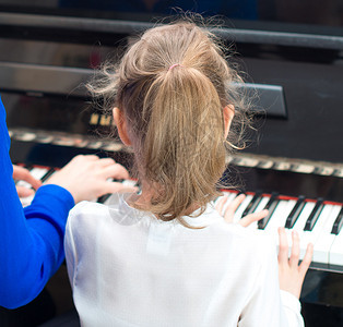 女人教小女孩弹钢琴图片