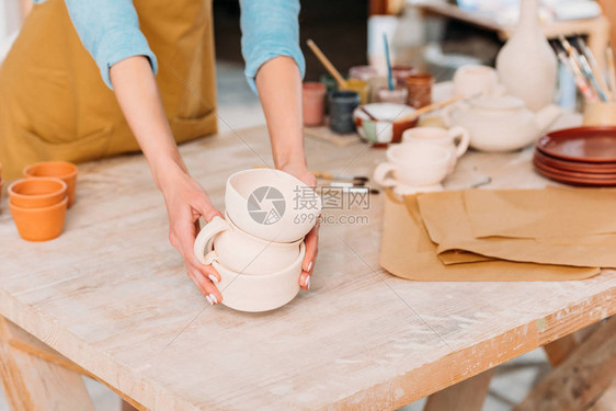 女陶艺家与陶瓷餐具的裁剪视图图片