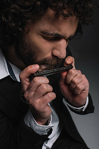 黑色口琴演奏的青年男子近背景图片