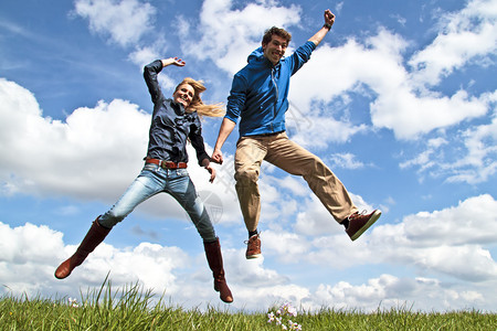 年轻的热心夫妇在空中跳跃图片