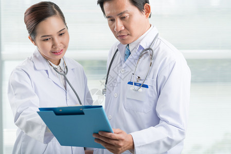 亚洲医生和护士一起阅读病人的病史图片