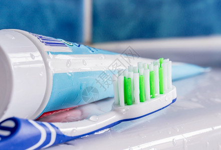 水槽牙膏管旁边的牙刷背景图片
