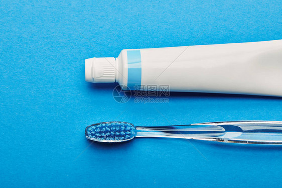 牙刷和牙膏按蓝色背景排列的牙刷和牙膏顶部视图片