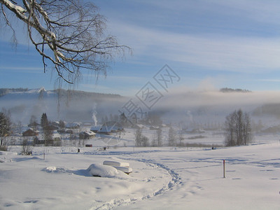 在山的早期和寒冷的冬天早晨背景是人工造雪机制造的雾前景雪地上的脚印和足迹这张照片是在芬兰斯堪的纳维亚欧洲的图片