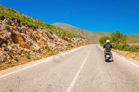 希腊卡利姆诺斯希腊岛空沥青公路上驾驶摩图片